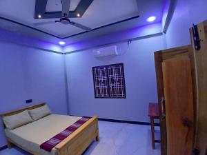 a bedroom with a bed and a ceiling with purple lights at AR villa in Jaffna