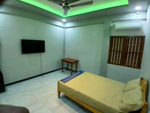 a room with a bed and a flat screen tv at AR villa in Jaffna