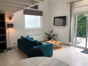 a living room with a blue couch and a table at Le loft 2 in Vouneuil-sous-Biard