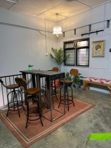 a dining room with a table and chairs at Roomah Ipoh En-suite attached-Bath R2 in Ipoh