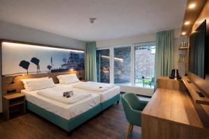 a hotel room with a bed and a television at Hotel Rheinpark Rees in Rees