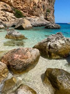 a group of rocks in the water on a beach at Casa FLORE in Orosei