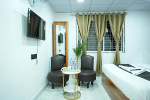 a hotel room with a bed and two chairs and a table at Elysia By THL-Near Westend Mall Aundh in Pune