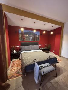 a bedroom with a bed and a red wall at Casa Barmalei Private Pool & Rooftop Terrace Ocean View, Tenerife in Callao Salvaje