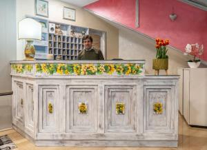 a man standing behind a counter with flowers on it at Cipriani Park Hotel in Rivisondoli