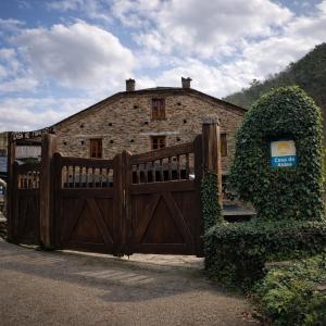 a wooden gate in front of a stone house at Casa do Fidalgo in A Pontenova
