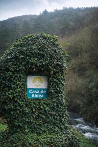 a bush with a sign in front of a river at Casa do Fidalgo in A Pontenova