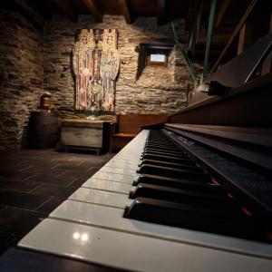 a piano in a room with a brick wall at Casa do Fidalgo in A Pontenova
