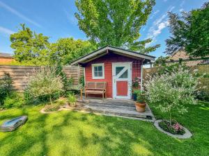 a small house with a red door in a yard at Apartmenthaus Tönning Sanddüne in Tönning