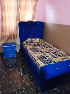 a bed in a room with a blue bed frame at Aduniniyi 7 Shines in Igando