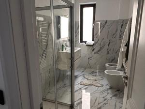a bathroom with a shower and a sink and a toilet at Hij Apartaments in Rădăuţi +7 photos