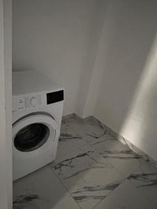 a washing machine in a room with a marble floor at Hij Apartaments in Rădăuţi