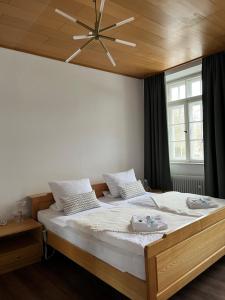 a bedroom with a large bed with a wooden ceiling at Kloster Altenhohenau FHN in Griesstätt