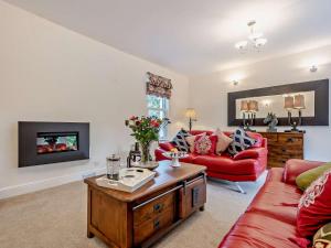 a living room with a red couch and a table at 3 Bed in Langholm oc-95053 in Langholm