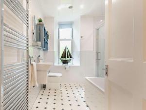a bathroom with a sink toilet and a sailboat in the window at 3 Bed in Langholm oc-95053 in Langholm +16 photos