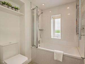a bathroom with a tub and a toilet and a window at 3 Bed in Crieff oc-92683 in Madderty +15 photos