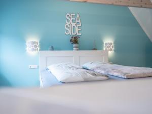 a bedroom with two beds with a blue wall at Hafensternchen in Husum
