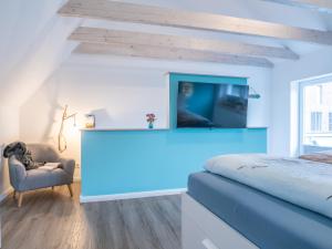 a bedroom with a bed and a tv and a chair at Hafensternchen in Husum