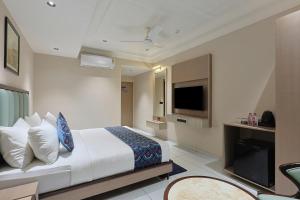 a hotel room with a bed and a flat screen tv at Hotel Ramida Suites IGI Delhi Airport in New Delhi
