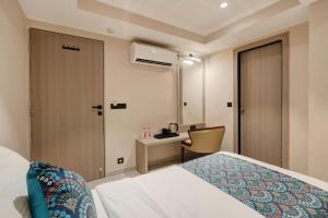 a hotel room with a bed and a desk at Hotel Ramida Suites IGI Delhi Airport in New Delhi