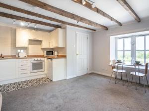 a kitchen with white cabinets and a table with chairs at 1 Bed in Biggar oc-82923 in Biggar +7 photos