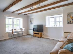 a living room with a tv and a table and chairs at 1 Bed in Biggar oc-82923 in Biggar