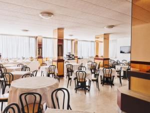 a banquet hall with white tables and chairs at Ilgo Hotel in Perugia