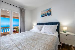 a bedroom with a bed with a view of the ocean at Apartments Mrkan 2 in Cavtat