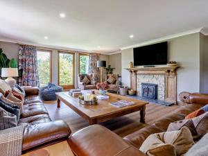 a living room with leather furniture and a fireplace at 6 Bed in Perth oc-96289 in Stanley
