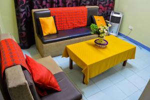 a living room with a yellow table and a couch at West Park Hotel in Nairobi