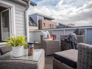 a patio with wicker chairs and a table on a balcony at Hafensternchen in Husum