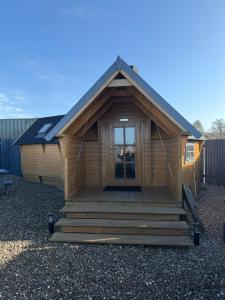 a log cabin with a porch and a door at The Nook Cardross in Cardross