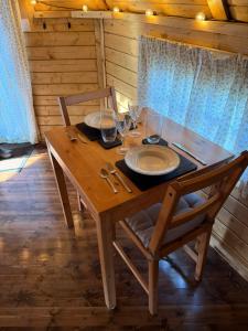 a wooden table with plates and wine glasses on it at The Nook Cardross in Cardross +17 photos