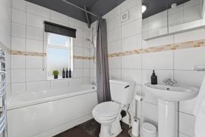 a white bathroom with a toilet and a sink at Delves House in Bescot +62 photos