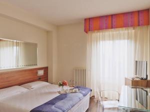 a bedroom with a bed and a table and a mirror at Ilgo Hotel in Perugia