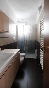 a bathroom with a shower and a toilet and a sink at La casa del tulipano in Bernalda