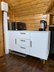 a white cabinet with a microwave on top of it at The Nook Cardross in Cardross