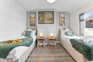 two beds in a room with two windows at Delves House in Bescot