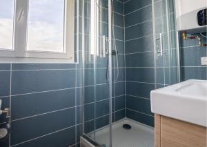 a blue tiled bathroom with a shower and a sink at L'espace de Robespierre in Saint-Denis