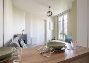 a dining room with a wooden table with bowls on it at L'espace de Robespierre in Saint-Denis +3 photos