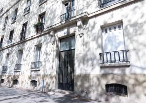 a white building with a window and a door at L'espace de Robespierre in Saint-Denis