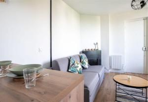a living room with a couch and a table at L'espace de Robespierre in Saint-Denis