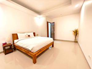 a bedroom with a bed in a white room at Nimis Villa in Canggu
