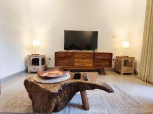 a living room with a tv and a coffee table at Nimis Villa in Canggu