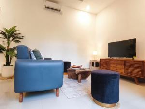 a living room with two blue chairs and a flat screen tv at Nimis Villa in Canggu +26 photos