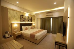 a hotel room with a bed and a television at Hotel Ramida Suites IGI Delhi Airport in New Delhi +22 photos