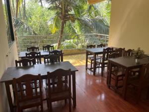 a restaurant with wooden tables and chairs and a balcony at SAHAY VILLA RESORT in Durbate