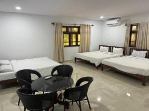 a room with two beds and a table and chairs at SAHAY VILLA RESORT in Durbate +57 photos