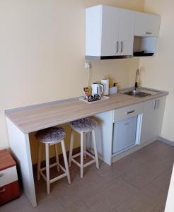 a kitchen with a counter and two bar stools at Apartmani Medijana Niš in Niš