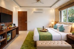 a bedroom with a large bed and a television at OPO Horizon LYRO Hotel , Formerly known as Inde Hotel in Gurgaon